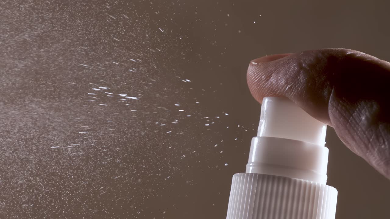 Liquid spraying fountain in a super slow motion of vaporized liquids particles. Shot on super slow motion camera 1600 fps. Spraying perfume