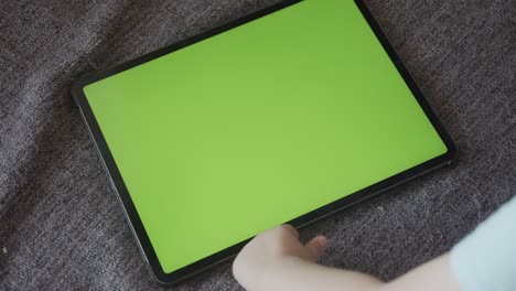 kid plays with fingers over green screen tablet display 4k video