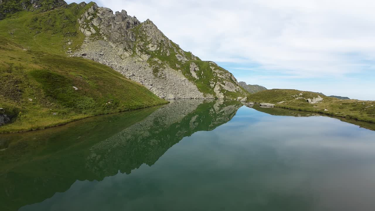 volando sobre el lago capra en las montañas fagaras, lago alpino turquesa en el corazón de rumania
