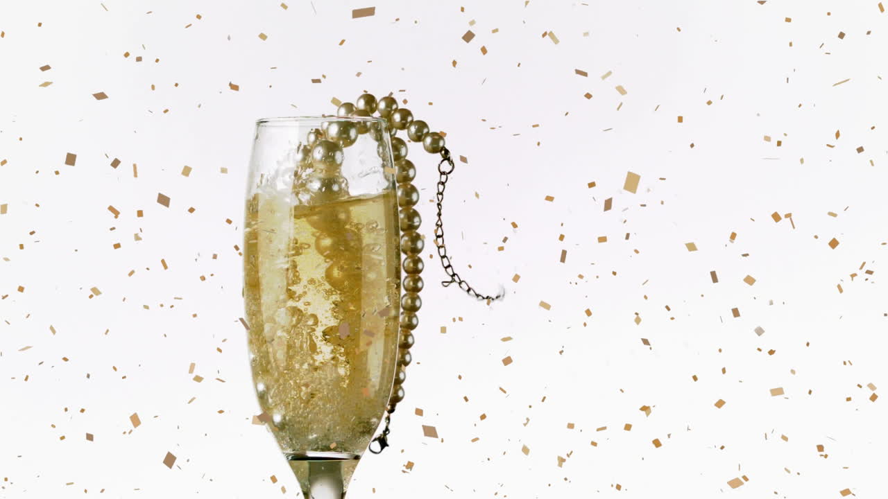 Animazione di coriandoli che cadono e collana di perle in un calice di champagne