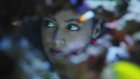 woman-looking-at-colorful-fish-in-aquarium-tank-watching-colorful-sea-life-swimming-in-corel-reef-observing-marine-ecosystem