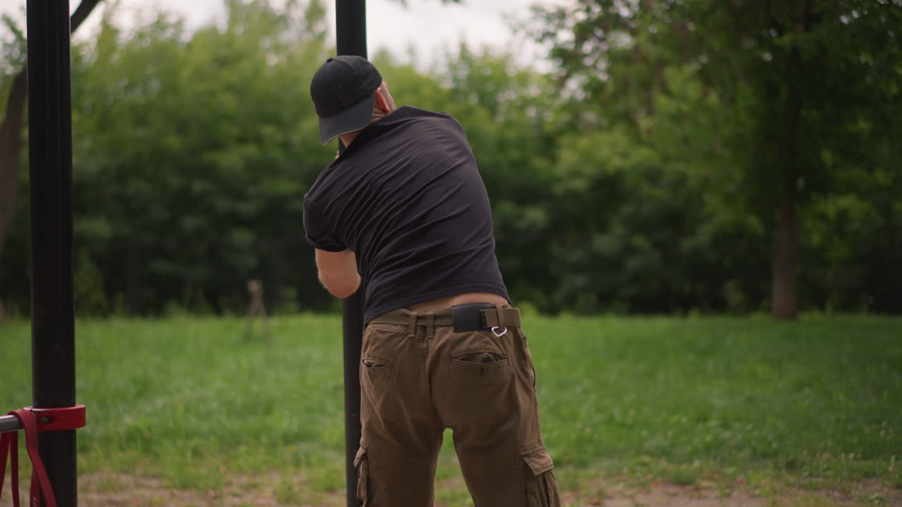 Person Maneuvers Staff In Park, Worker Demonstrating Strength While Maintaining Stable Footing During Task, Man Utilizing Effort To Insert Pole In Park Environment With Steady Balance And Focus