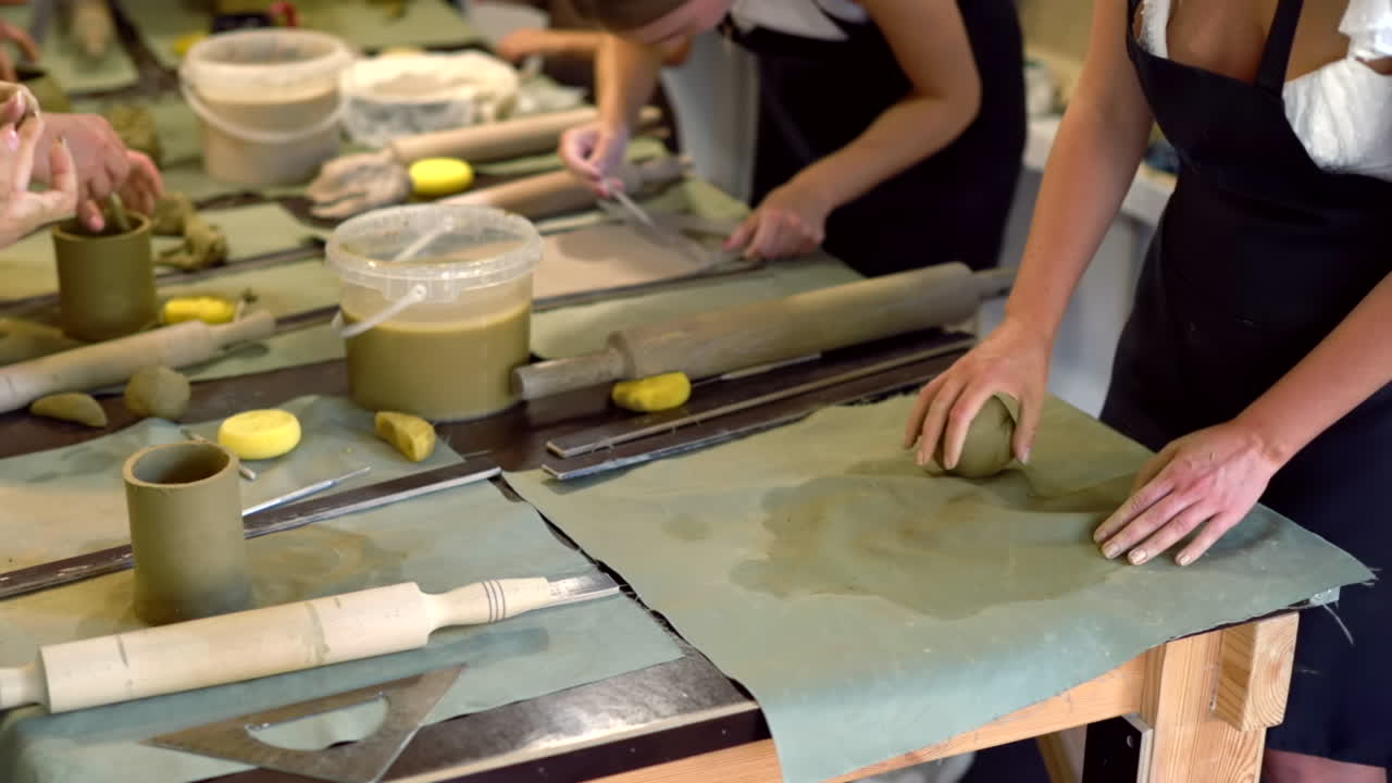 Students rolling out clay with a rolling pin