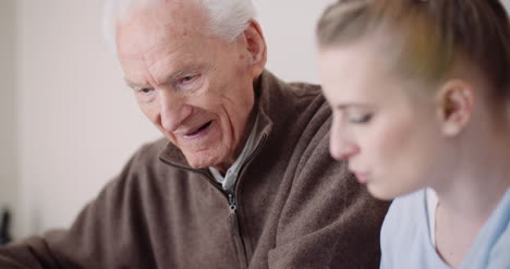 old man retirement smiling senior man talking with granddaughter