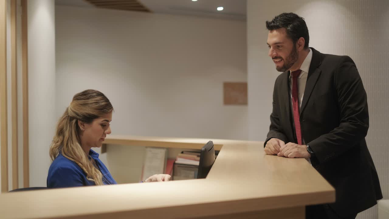 Donna felice al lavoro come receptionist d'hotel che accetta una carta di credito