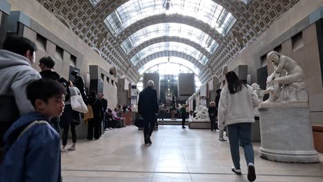 visitors exploring and admiring sculptures in a museum