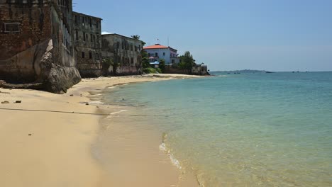 Tropischer-Sandstrand-Und-Meer-In-Sansibar-Mit-Wunderschönem-Türkisblauem,-Kristallklarem-Meerwasser-Und-Wellen,-Die-An-Einem-Sonnigen-Tag-In-Tansania,-Afrika,-Ans-Ufer-Plätschern,-Mit-Klarem-Blauen-Himmel