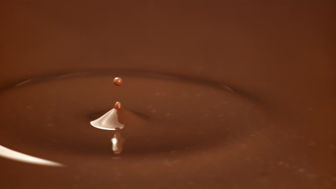 スローモーションで飛び散る一滴のチョコレート液