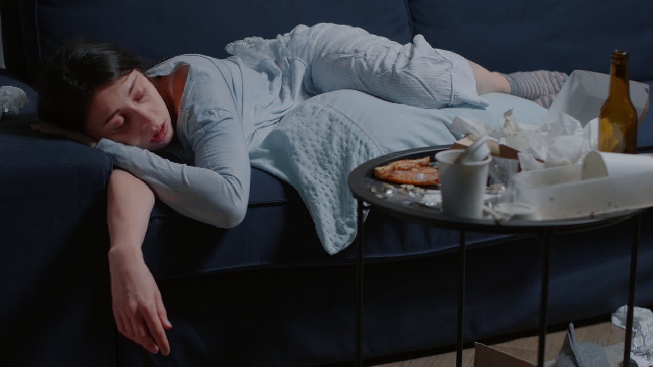 Depressed woman lying alone on sofa feeling tired vulnerable weak crying