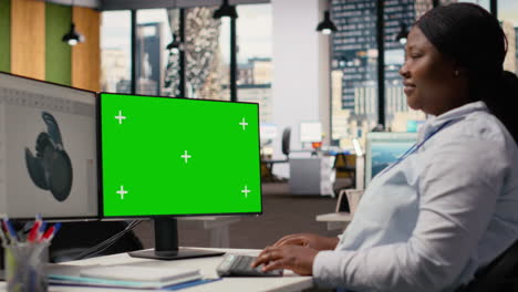 wind energy researcher analyzes turbine component on green screen pc