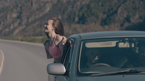 happy lady looks out speeding car window and enjoys life