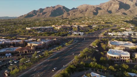 aerial footage of catalina foothills neighborhood on golden sunny day, busy intersection and shopping plaza below