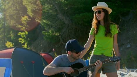 pareja acampando cerca del río 4k