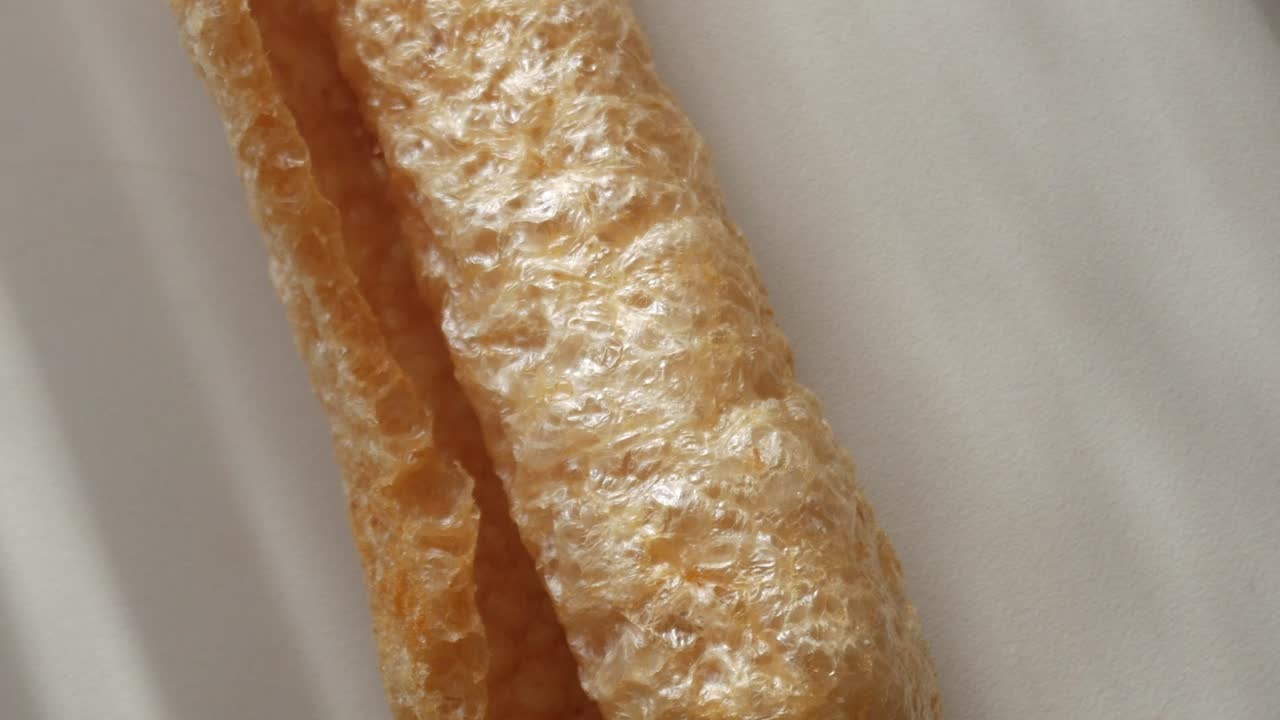 Crunchy pork rind, close-up shot highlighting texture and shape of the snack