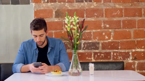 Handsome-man-using-mobile-phone-at-table-4k