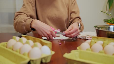woman trimming flowers and wrapping eggs for natural easter dyeing tradition