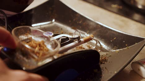 creando un cigarrillo con una pequeña máquina