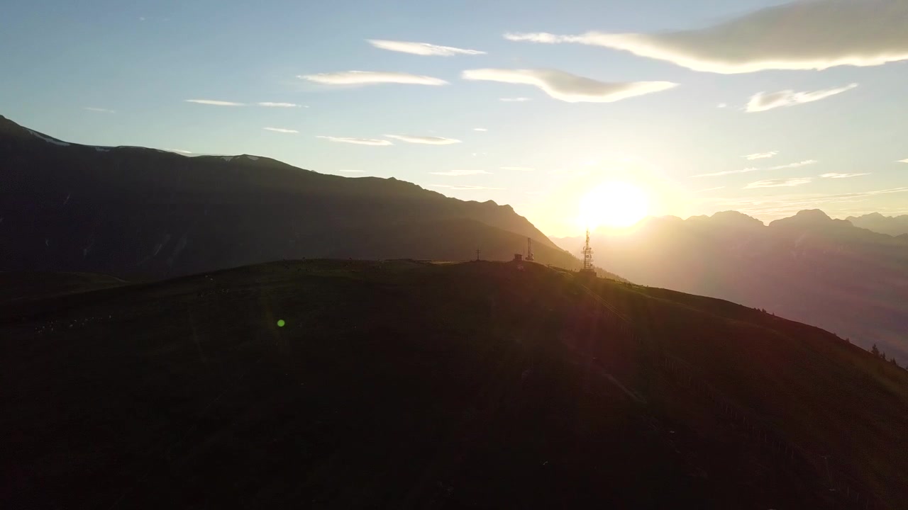 Tramonto dietro un'ampia cima di montagna.