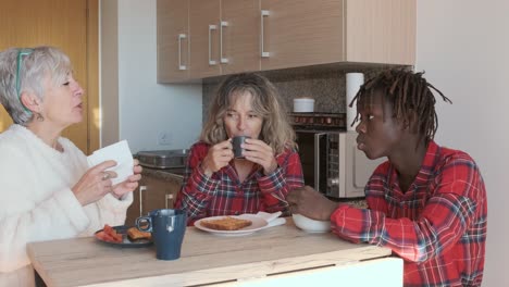 a group of people having breakfast in a kitchen