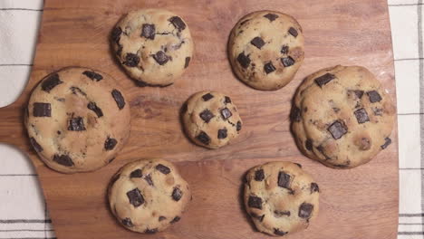 dough with roling pin turned into round cookie chips on wooden board