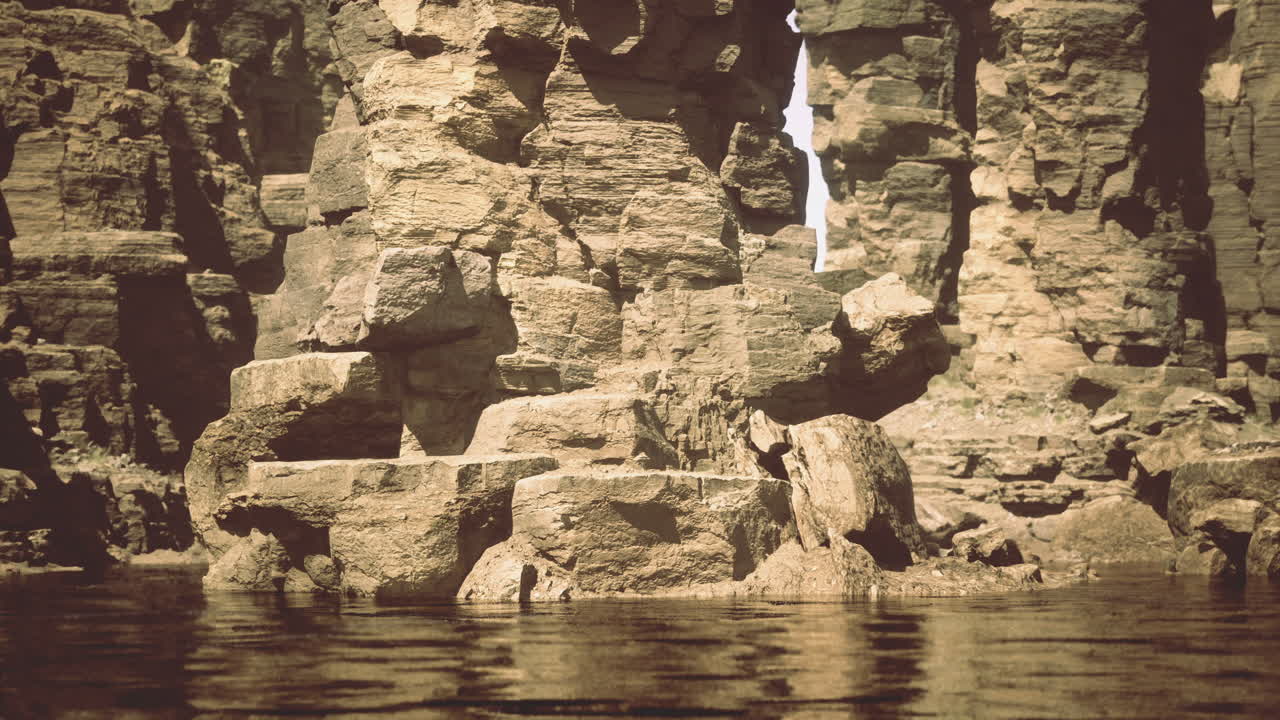 Majestic rock formations tower above tranquil waters in a serene landscape