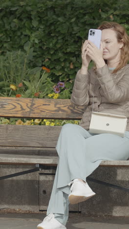 woman taking a photo in a park