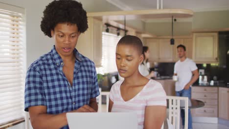 Diverse-male-and-female-friends-working-in-kitchen-and-talking