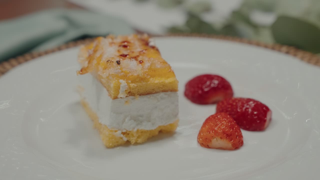 Elegant dessert layered cream cake and sliced strawberries served on white plate in soft lighting