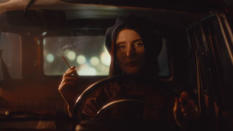 stylish young female driver smoking during night ride in retro car