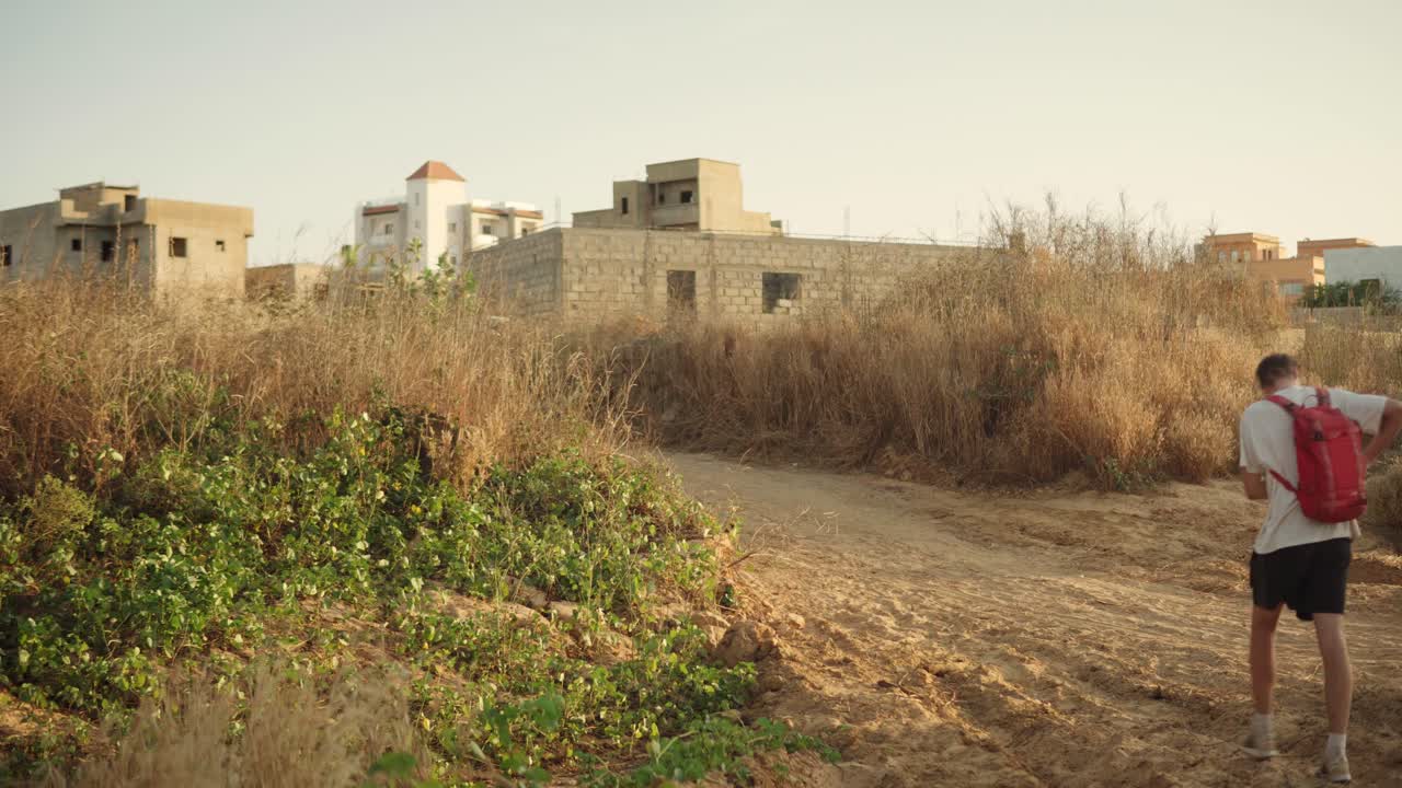 Uomo bianco cammina su un sentiero sterrato in Senegal, Africa