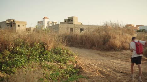 Weißer-Mann-Geht-Im-Senegal,-Afrika,-Einen-Feldweg-Hinauf