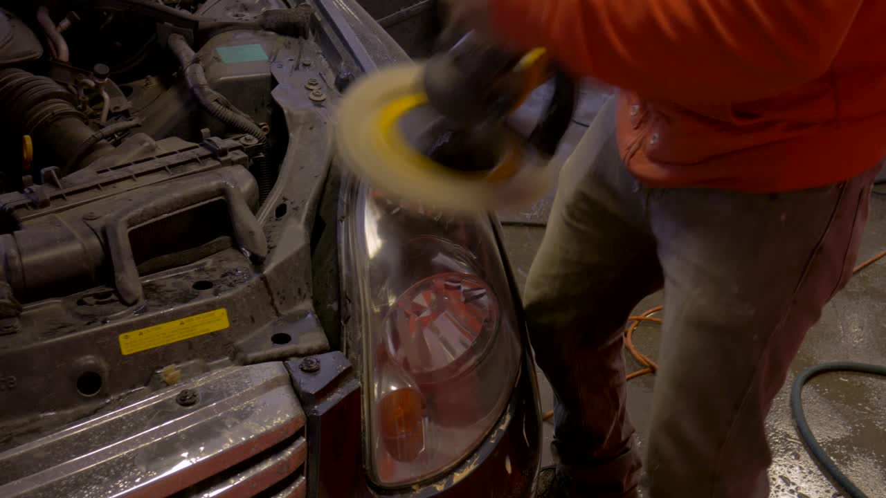 A man buffing car headlight.