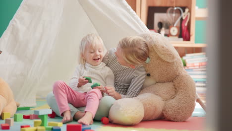 cube, girl and siblings with laughing on floor