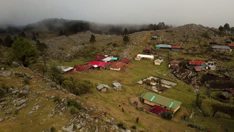 Toma-Aérea-De-Casas-En-Las-Montañas-Rocosas-De-Nebaj,-Quiche-En-Guatemala,-Durante-La-Mañana