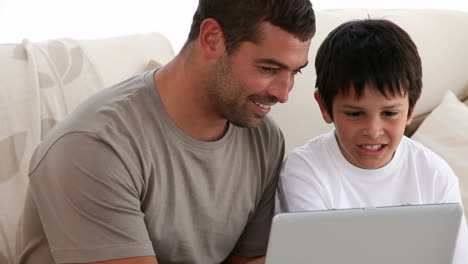 padre e hijo jugando con una computadora
