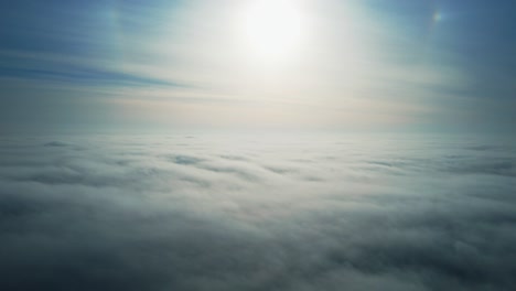 aerial flying above clouds with sun