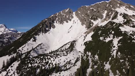 Drone-shot-of-Austrian-Alps-surrounded-by-Snowy-Mountain-Winter-Landscape-in-Ski-Area,-Bludenz,-Austria,-Europe