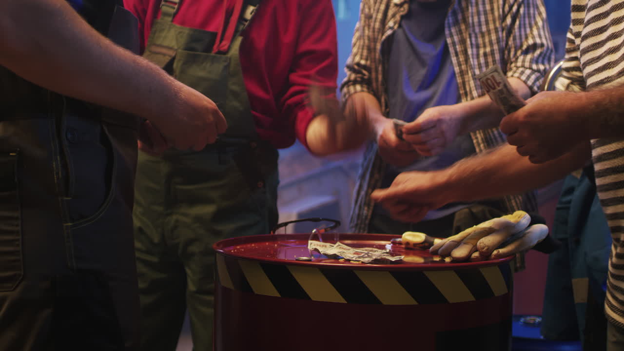 Workers handling money around a barrel