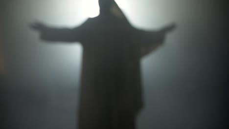 silhouette of resurrection of jesus christ inside the tomb, in bright light, raising his hands in dramatic, cinematic slow motion. perfect for easter resurrection visual.