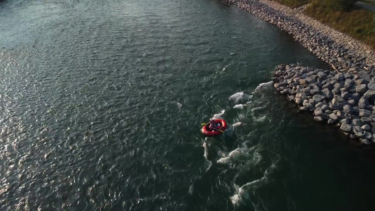 Barca che scende le rapide di un fiume, ripresa dall'alto in una giornata di sole