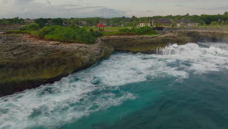 powerfull waves rolling into tourist spot devil's tears on rocky coastline of nusa lembongan