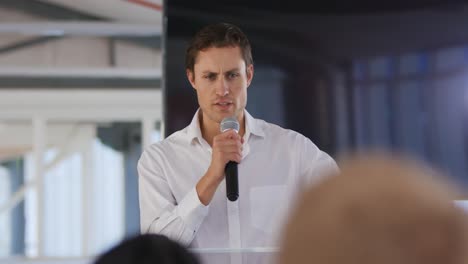 male speaker addressing the audience at a business conference