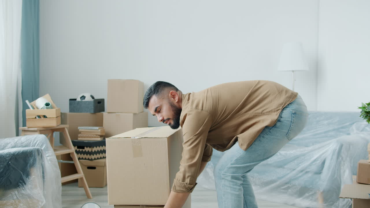 Man struggling to move boxes during a house move