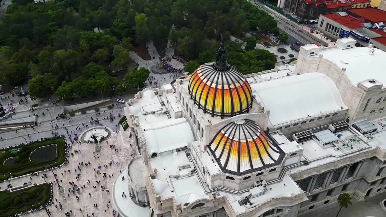 İkonik Palacio de Bellas Artes'ı yakalayan, muhteşem beyaz mermer mimarisini ve kendine özgü turuncu-sarı tonlu camını vurgulayan nefes kesici sinematik yüksek açılı havadan drone görüntüsü.