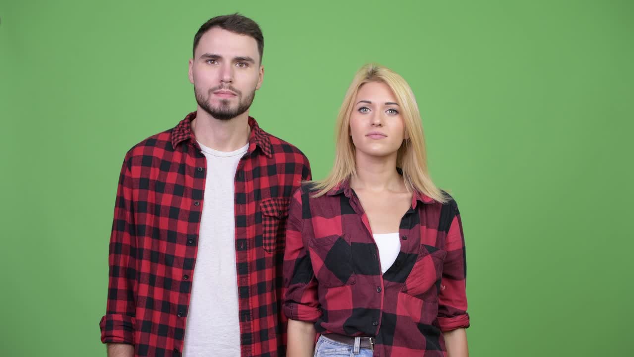 Young couple pointing finger up together