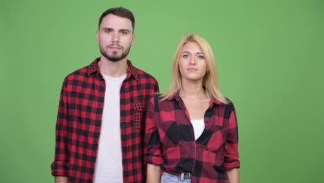 young couple pointing finger up together