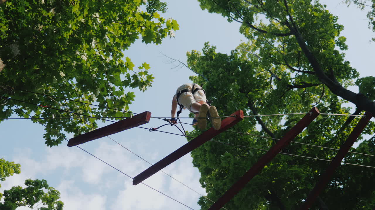 un niño valiente da pasos en un cable escalonado a una altura que supera el concepto de miedo