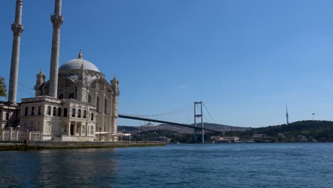 Mezquita-De-Ortakoy-Con-El-Puente-Del-Bósforo-Al-Fondo,-Estambul,-Turquía,-Sol