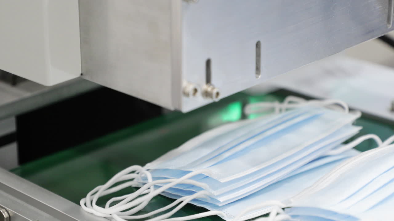 máquina para fabricar mascarillas médicas - línea de producción de mascarillas - primer plano, panorámica hacia la derecha