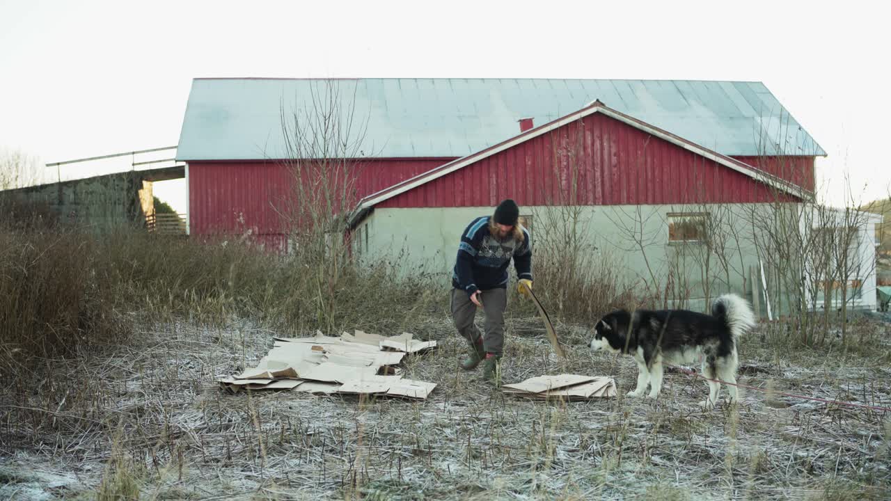 한 사람 이 카드보드 를 재료 로 사용 하기 위해 준비 하고 있으며, 그 의 개 는 그  에 있다 - 정적